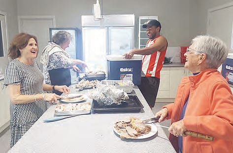 Sandra, Jenny, Sammi, and Joyce sharing both the laughter and the workload as they carve up the smoked meats for the meals. Photo: The Buloke Times