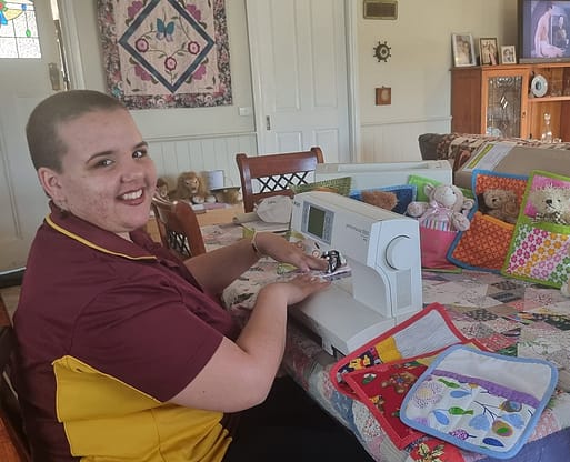 Chenoa sewing hugs in a rug