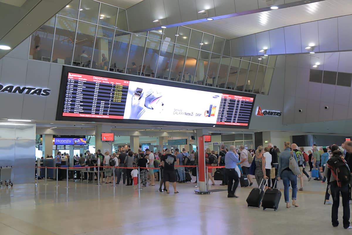 People queue at Melbourne Airport Qantas Domestic departure gaten