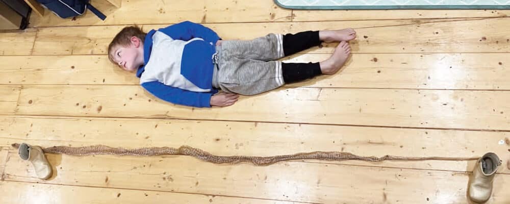 Erik lying with 2050mm long snake skin. Photo: The Buloke Times