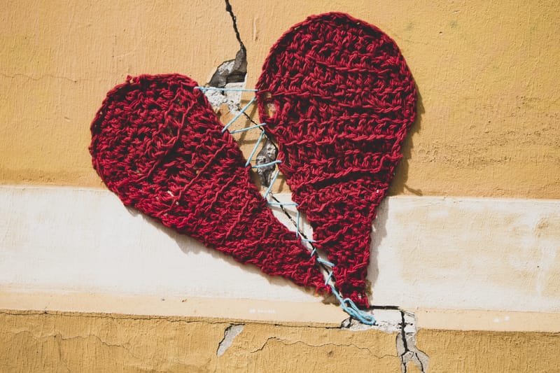 Knitted heart over crack in wall